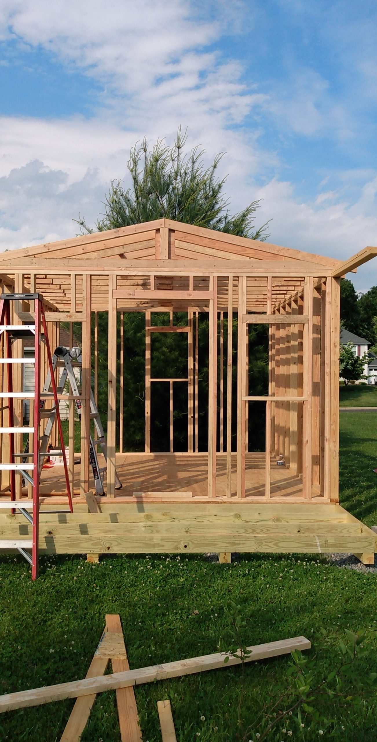 Framing of a new sunroom addition on a pressure-treated deck platform