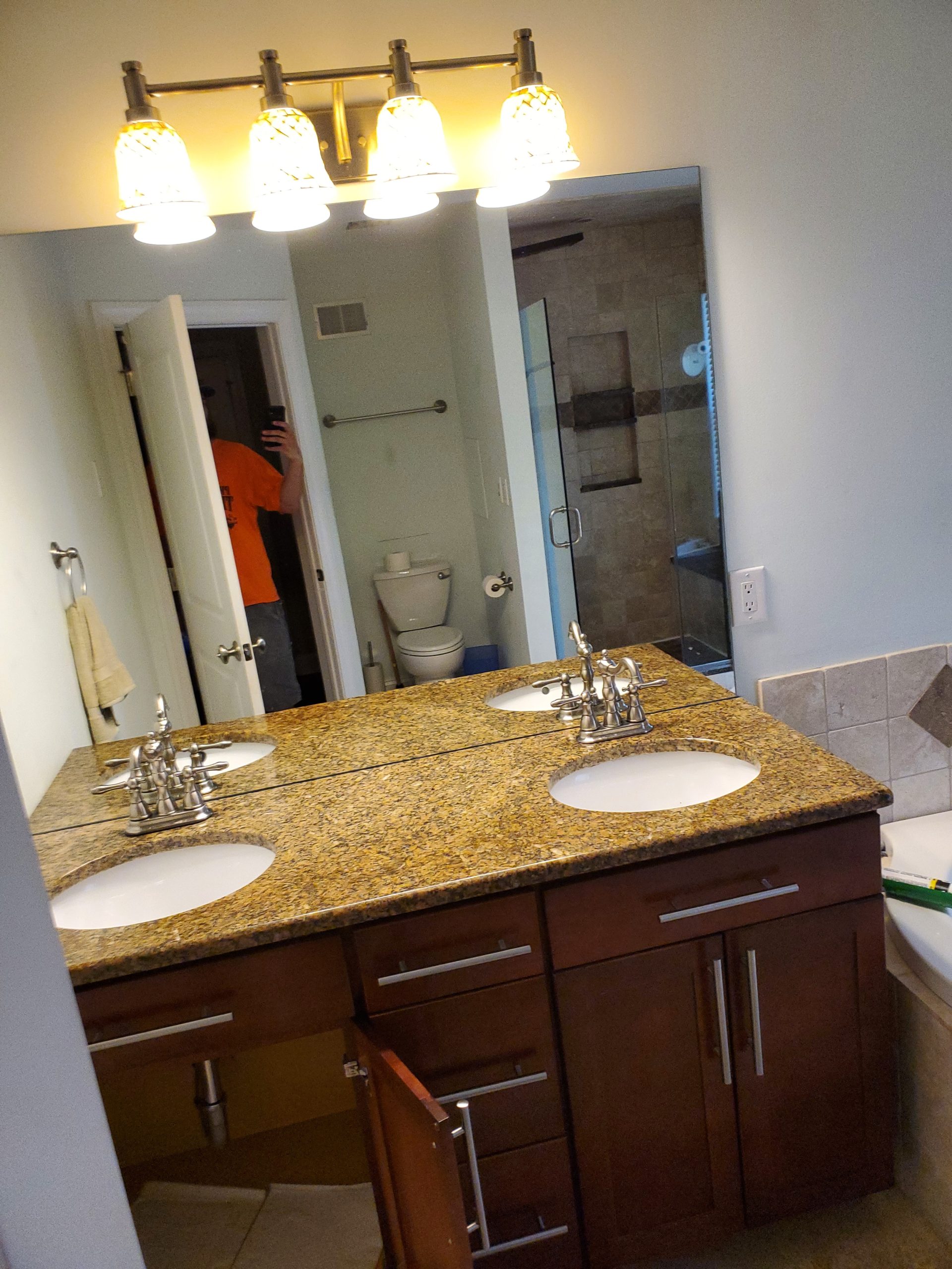 Double vanity with granite countertop and dark wood cabinets