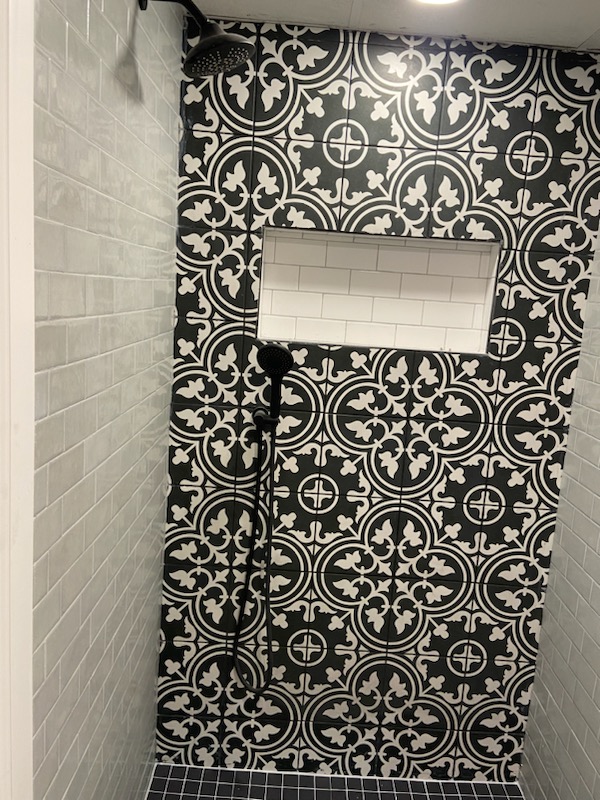 Black-and-white patterned shower tile with a recessed shampoo niche