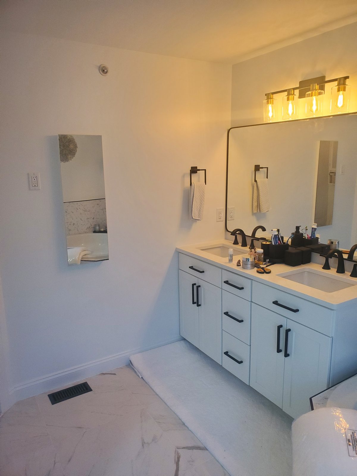New master bathroom double vanity with quartz countertop, matte black faucets and a gold framed mirror