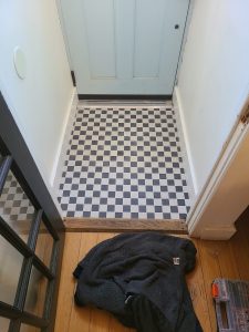 Entry vestibule after renovation with a black and white checkerboard tile floor
