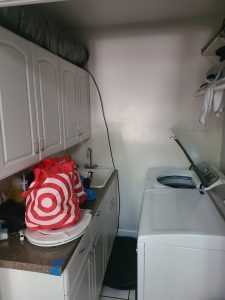 Laundry room with utility sink, white wall cabinets and a washer and dryer