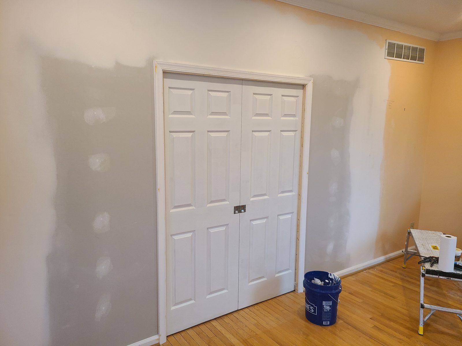 Bedroom wall patched and skim coated around a new closet opening, primed and ready for paint