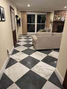 Living room after with a black and white marble look checkerboard tile floor