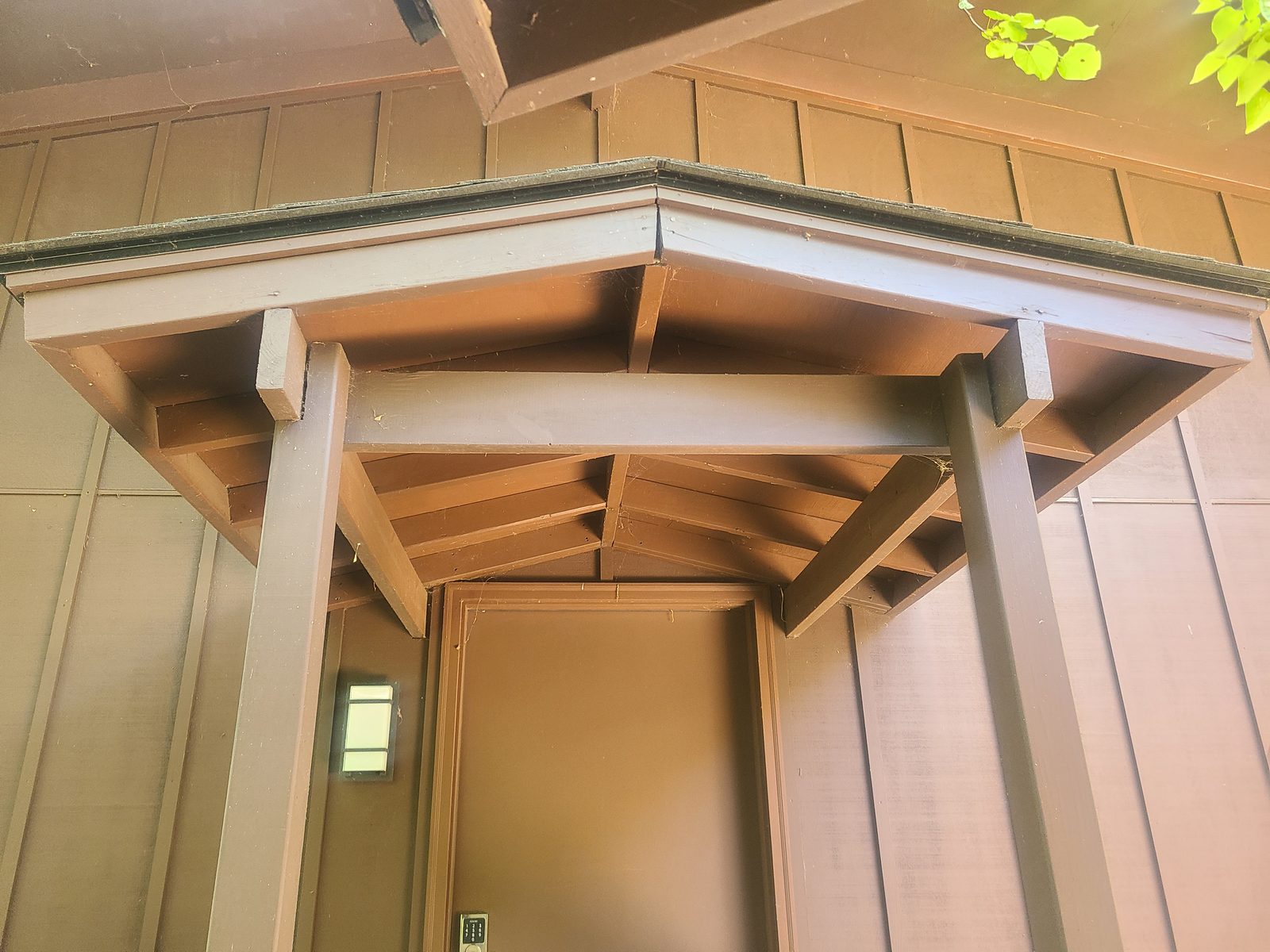 Underside of the original entry porch roof showing the beam and rafter framing