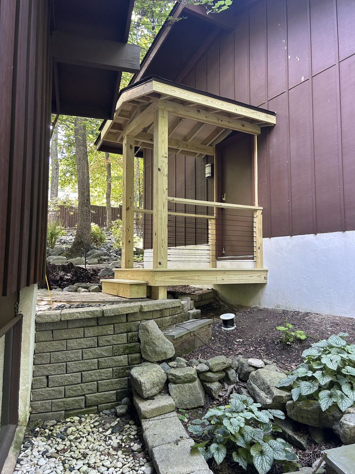 Rebuilt entry porch in pressure treated lumber with a new roof, railing and steps