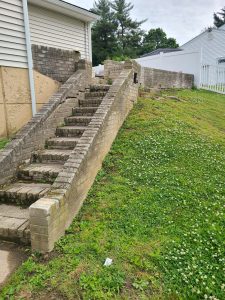 Deteriorating block steps and retaining wall alongside the house before replacement