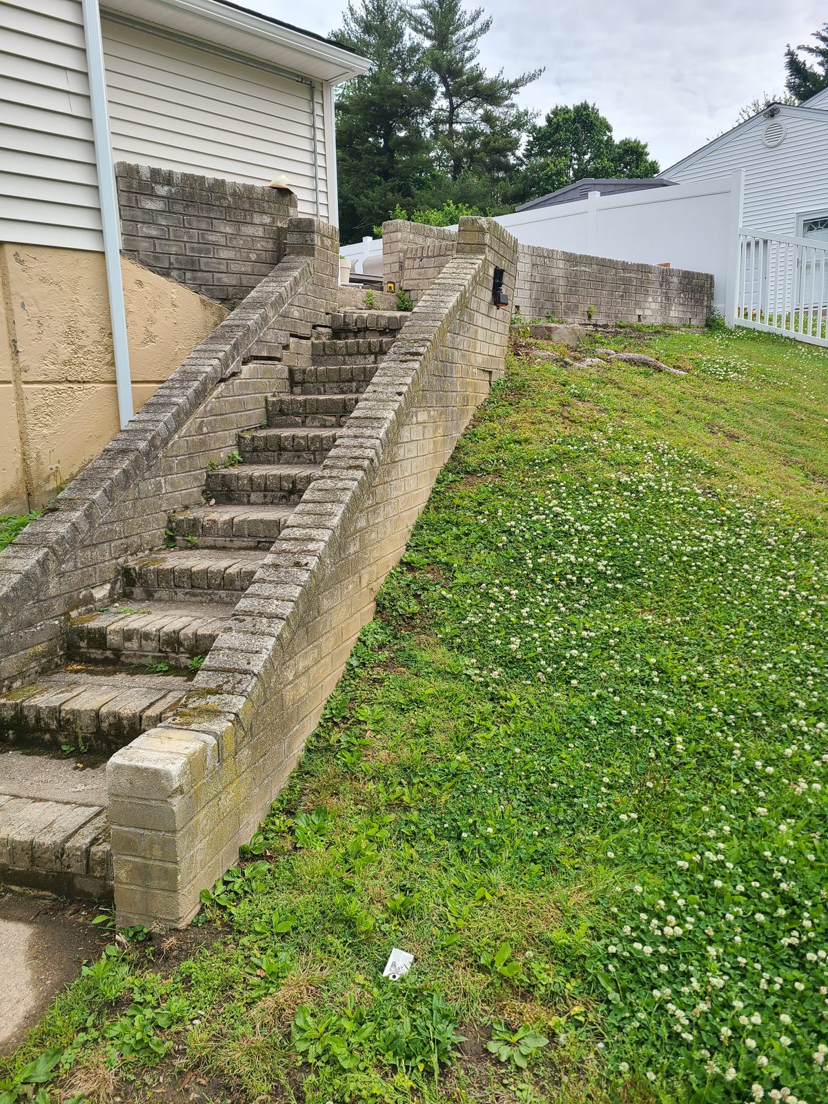 Deteriorating block steps and retaining wall alongside the house before replacement