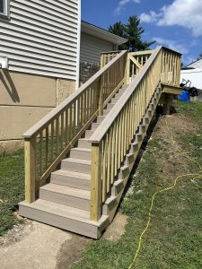 New pressure treated exterior staircase with railings replacing the old block steps