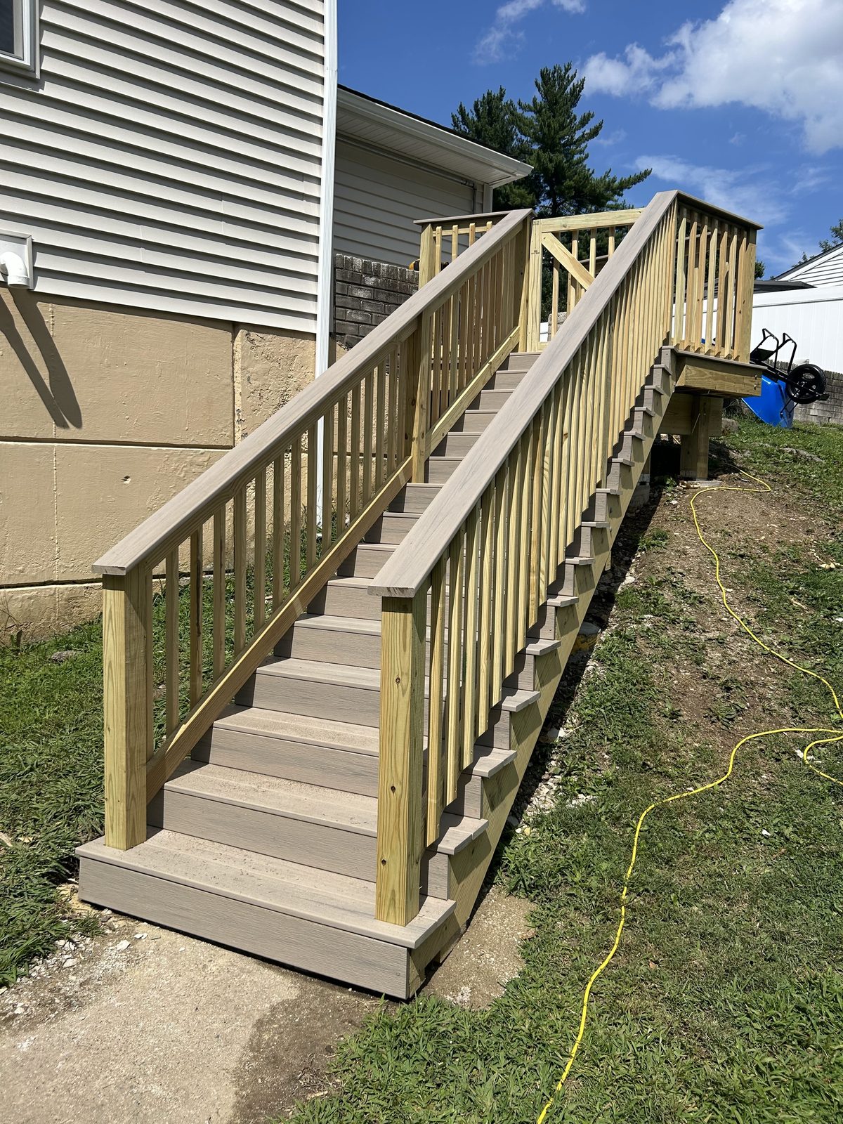 New pressure treated exterior staircase with railings replacing the old block steps