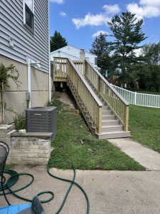 New wood staircase and landing running alongside the house down to the walkway