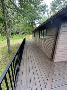 Composite deck walkway with black aluminum railing running along the side of the house