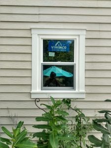 New white vinyl replacement window with custom exterior trim in vinyl siding