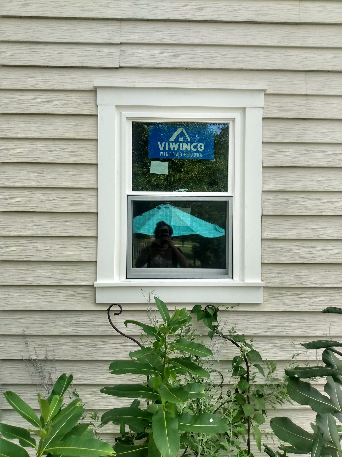 New white vinyl replacement window with custom exterior trim in vinyl siding